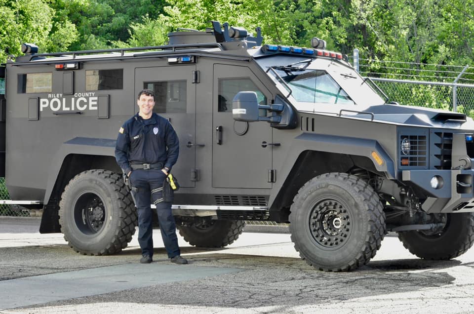 Police Officer Standing in Front of an Armored Police Vehicle