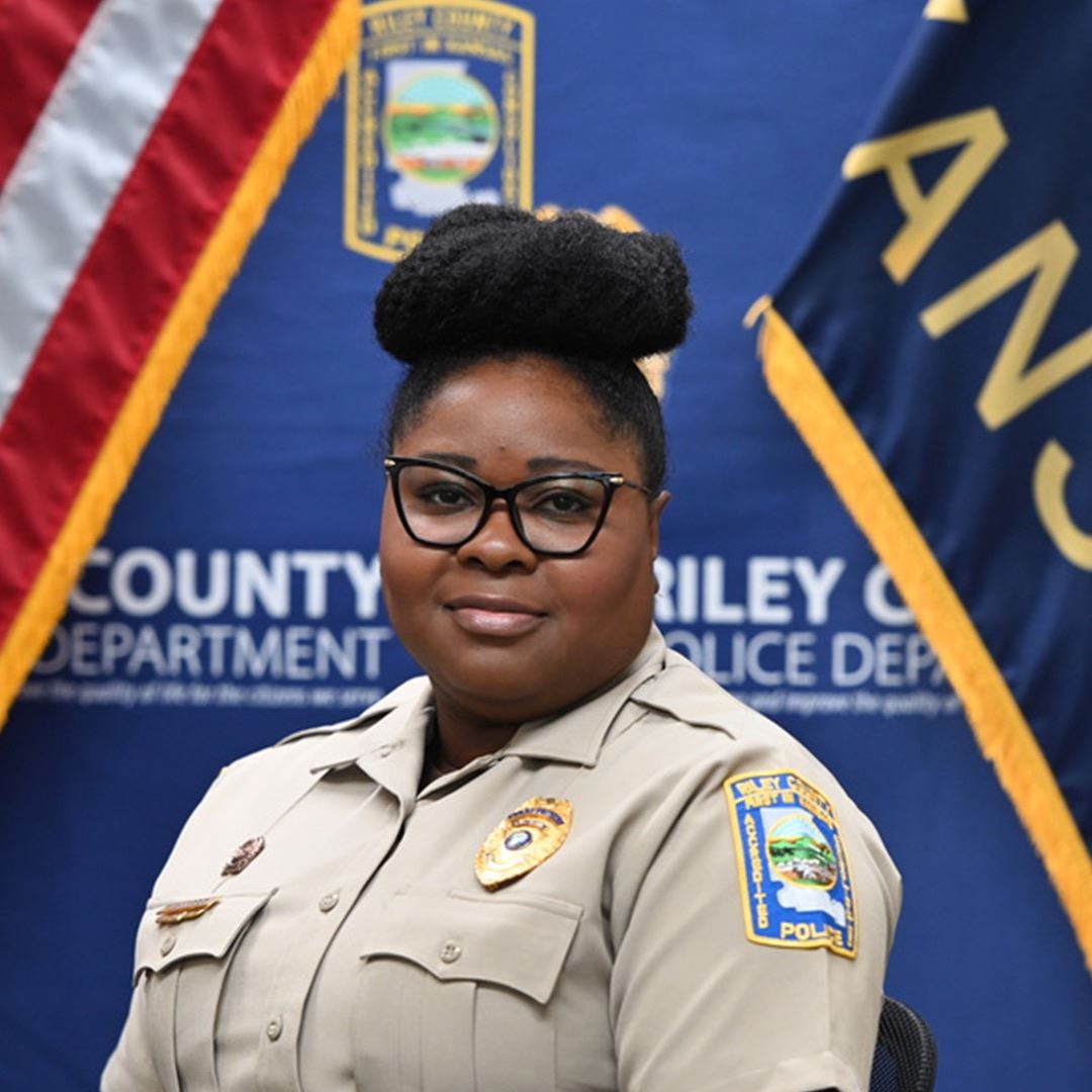 Corrections Officer in a light brown blouse